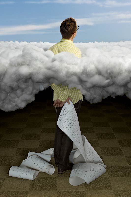 Un homme de dos face à un mur de nuages, tenant de longues notes manuscrites